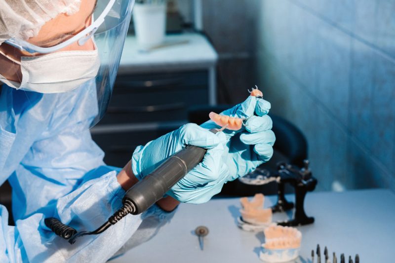 tehnician dentar in timpul unei lucrari de finisare